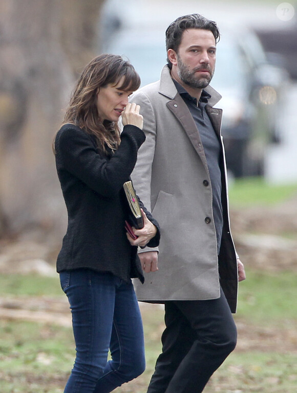 Ben Affleck et sa femme Jennifer Garner, complices dans les rues de Brentwood, le 11 décembre 2014. Ben fume une cigarette et se désaltère ensuite avec un Perrier.