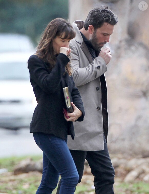 Ben Affleck et sa femme Jennifer Garner, complices dans les rues de Brentwood, le 11 décembre 2014. Ben fume une cigarette et se désaltère ensuite avec un Perrier.