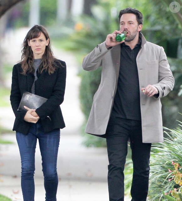 Ben Affleck et sa femme Jennifer Garner, complices dans les rues de Brentwood, le 11 décembre 2014. Ben fume une cigarette et se désaltère ensuite avec un Perrier.