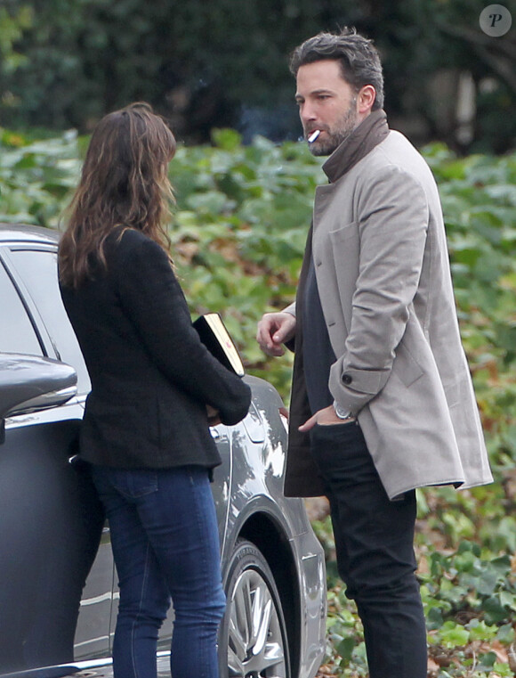 Ben Affleck et sa femme Jennifer Garner, complices dans les rues de Brentwood, le 11 décembre 2014. Ben fume une cigarette et se désaltère ensuite avec un Perrier.
