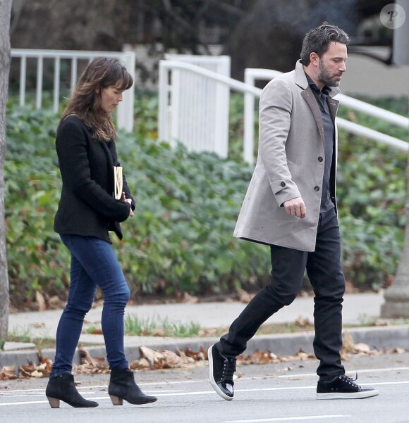 Ben Affleck et sa femme Jennifer Garner, complices dans les rues de Brentwood, le 11 décembre 2014. Ben fume une cigarette et se désaltère ensuite avec un Perrier.