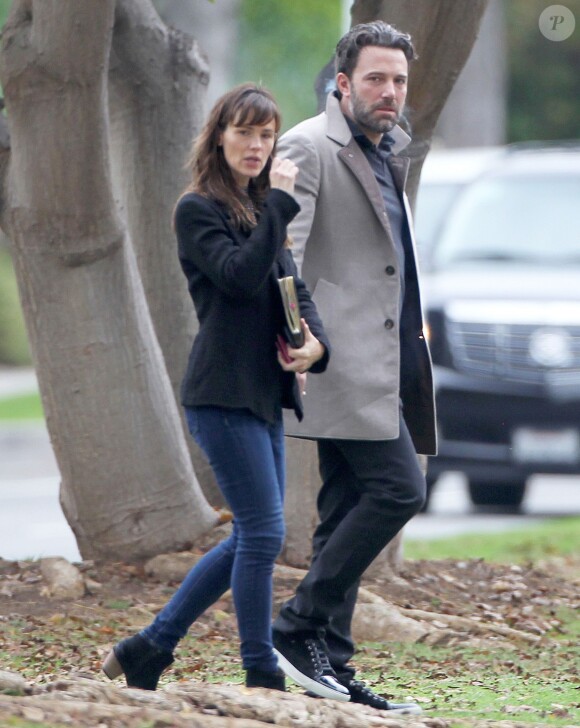 Ben Affleck et sa femme Jennifer Garner, complices dans les rues de Brentwood, le 11 décembre 2014. Ben fume une cigarette et se désaltère ensuite avec un Perrier.