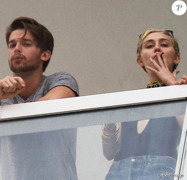 Exclusif - Miley Cyrus et son petit ami Patrick Schwarzenegger fument une drôle de cigarette au balcon de leur chambre d'hôtel à Miami, le 4 décembre 2014