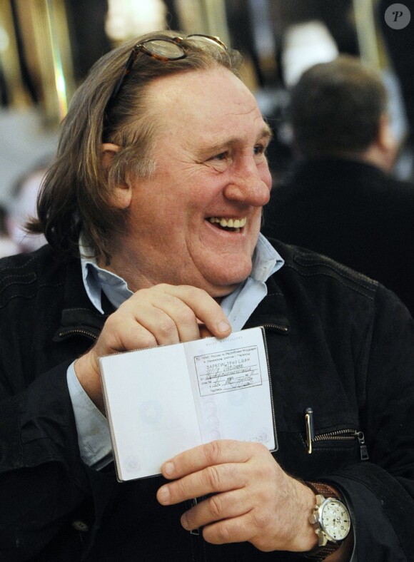 Gérard Depardieu montre fièrement son passeport de citoyen Russe lors de sa visite à Saransk. Il aura pour adresse d'enregistrement la "rue de la Démocratie". Le 23 février 2013