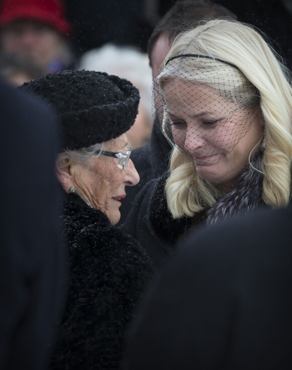 La princesse Mette-Marit de Norvège réconfortant la princesse Astrid aux obsèques de son mari Johan Martin Ferner, le 2 février 2015 en la chapelle d'Holmenkollen, en périphérie d'Oslo.