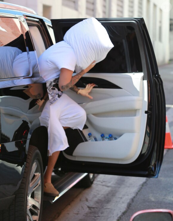 Justin Bieber se cache avec un oreiller alors qu'il se rend chez le médecin à Beverly Hills, le 23 mars 2015.