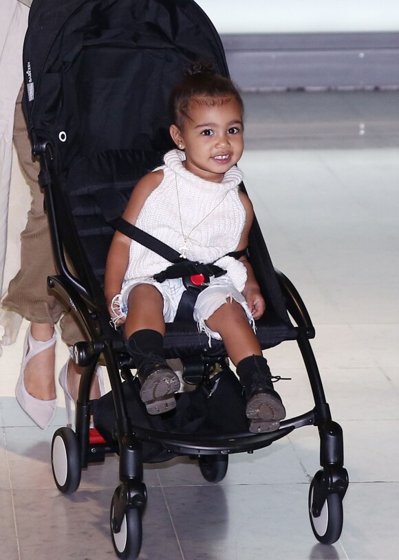 North West, confortablement assise dans sa poussette, arrive à l'aéroport de Roissy-Charles-de-Gaulle avec ses parents Kim Kardashian et Kanye West. Roissy, le 14 avril 2015.