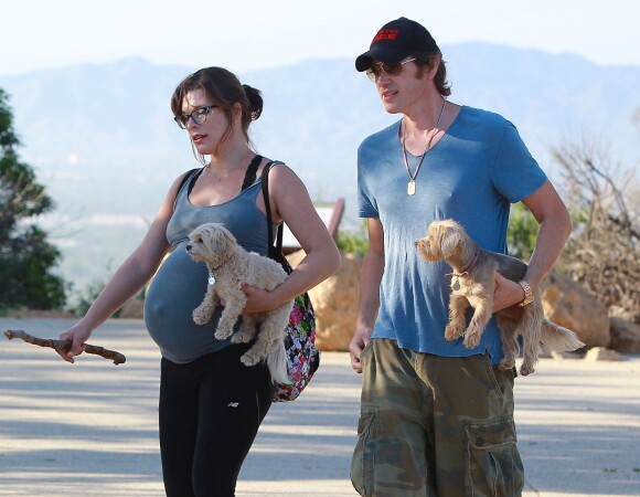 Exclusif - Milla Jovovich très enceinte fait de la randonnée avec son mari Paul W.S Anderson et leurs chiens à Los Angeles, le 24 mars 2015.