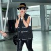 Rita Ora arrive à l'aéroport JFK à New York habillée d'un gilet noir, d'un pantalon en cuir et de bottines Tommy Hilfiger. Un chapeau noir, un sac Chanel, une montre Rolex et un bracelet Cartier (collection Juste un clou) accessoirisent sa tenue. Le 6 mai 2015.