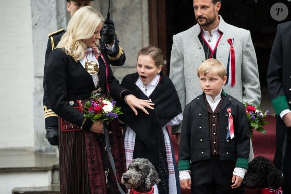Ingrid Alexandra serait bien restée au lit un peu plus... La princesse Mette-Marit, le prince Haakon, leurs enfants la princesse Ingrid Alexandra, le prince Sverre Magnus et le grand Marius Borg se sont présentés de bon matin sur le perron de leur résidence de Skaugum pour célébrer la Fête nationale, le 17 mai 2015 à Oslo