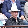 Raymond Domenech et sa compagne Estelle Denis dans les tribunes des Internationaux de France de tennis de Roland-Garros à Paris, le 1er juin 2015.