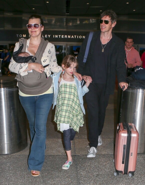 Milla Jovovich, son mari et leurs deux filles Ever et Dashiel arrivent à l'aéroport de LAX à Los Angeles, le 19 juin 2015. 