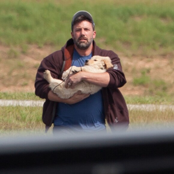Ben Affleck est venu à Atlanta en avion privé pour voir ses enfants le 20 juillet 2015. Il tient dans ses bras un adorable labrador chiot