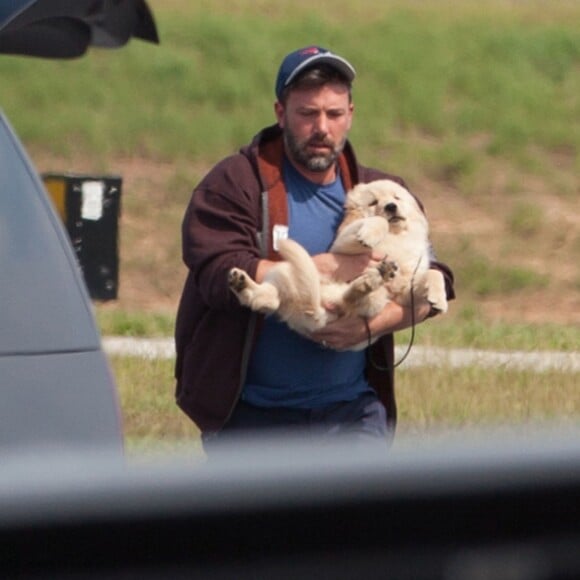 Ben Affleck est venu à Atlanta en avion privé pour voir ses enfants le 20 juillet 2015. Il tient dans ses bras un adorable labrador chiot