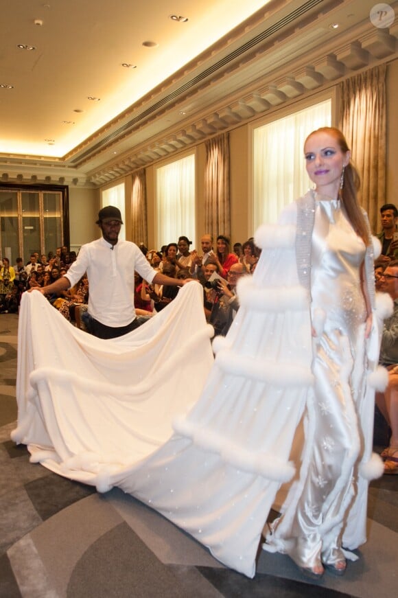 Le créateur et sa robe de mariée au défilé de mode Manu Reas haute couture automne-hiver 2015-2016 à l'hôtel The Peninsula à Paris, le 8 juillet 2015.