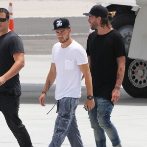 Harry Styles, Liam Payne, Louis Tomlinson, et Niall Horan du groupe One Direction montent à bord d'un jet privé à l'aéroport de Van Nuys, le 21 juillet 2015. Des fans sont venus à l'aéroport dans l'espoir de les apercevoir !  