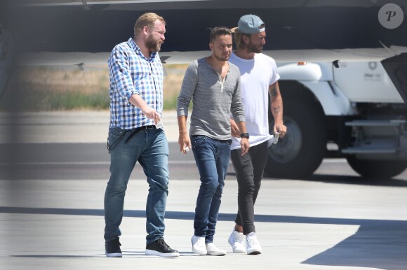 Les membres de One Direction embarquent à bord d'un jet privé pour leur US Tour le 15 juillet 2015. Le futur papa Louis Tomlinson porte d'une veste rouge et Liam Payne arrive accompagné d'un ami..  