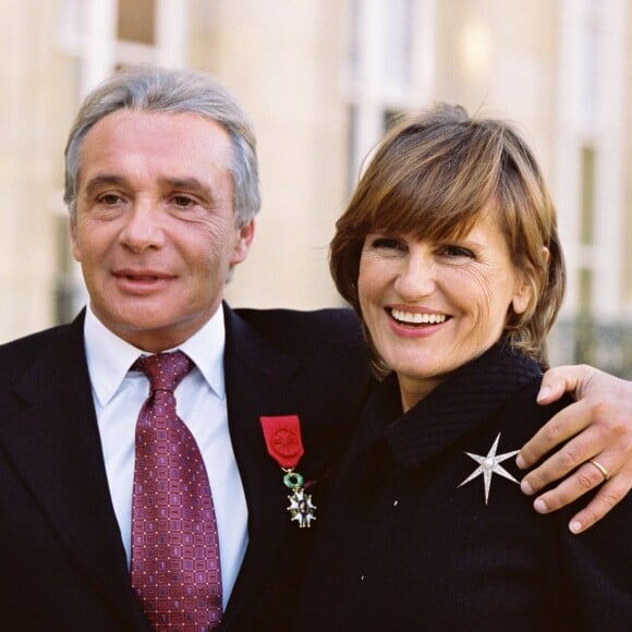 Michel Sardou reçoit la Légion d'honneur à l'Elysée au côté de son épouse Anne-Marie Périer, le 16 novembre 2001.