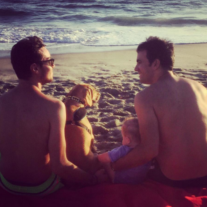 Alex Goude, son mari Romain, leur fils Elliot et leur chien au bord de la plage. Août 2015.