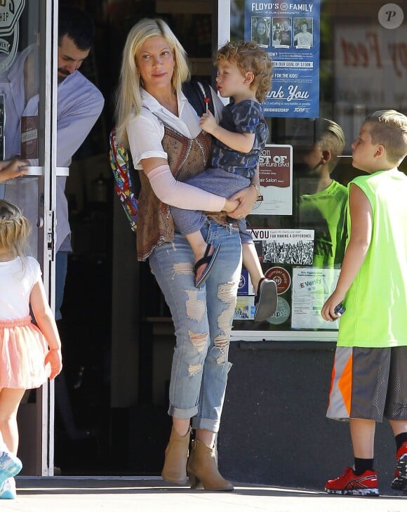 Exclusif - Tori Spelling se promène avec un inconnu et avec ses enfants Liam, Stella, Finn et Hattie dans les rues de Tarzana. Le petit Liam est allé chez le coiffeur «Floyd Barbershop» et la petite famille est allée ensuite diner dans un restaurant mexicain. Tori porte toujours son bandage. L'actrice américaine de 42 ans a décidé de porter plainte contre la chaîne de restaurants Benihana, qu'elle estime responsable de sa vilaine brûlure au bras droit. Le 6 septembre 2015