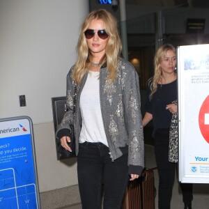 Rosie Huntington-Whiteley à l'aéroport LAX à Los Angeles, porte un bomber Dries Van Noten, un t-shirt blanc et un jean Paige, un sac Saint Laurent et des bottines Isabel Marant. Le 21 octobre 2015.