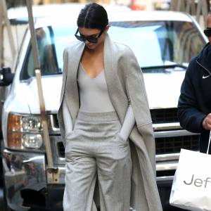 Kendall Jenner à New York, porte une cape et un pantalon gris Sally Lapointe (collection automne-hiver 2015), un body en néoprène Atea, et des souliers Saint Laurent. Des lunettes de soleil Céline accessoirisent sa tenue. Le 20 octobre 2015.