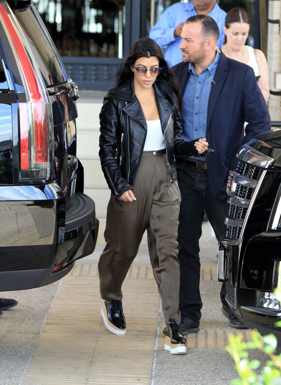 Kourtney Kardashian quitte le centre commercial Barneys New York, habillée d'un perfecto en cuir Balenciaga, d'un body blanc Wolford, d'un pantalon kaki et de chaussures Stella McCartney. Los Angeles, le 19 octobre 2015.