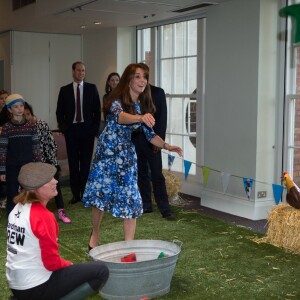 Kate Middleton, duchesse de Cambridge, en plein lancer de botte en caoutchouc, le prince William et le prince Harry se sont bien amusés, le 26 octobre 2015 au siège de la BAFTA, lors d'une rencontre avec des enfants dans le cadre de The Charities Forum, un événement rassemblant une trentaine d'associations qu'ils soutiennent.