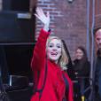 La chanteuse Adele salue ses fans habillée d'un manteau rouge au Joe's pub de New York le 20 novembre 2015.