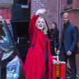 La chanteuse Adele salue ses fans habillée d'un manteau rouge au Joe's pub de New York le 20 novembre 2015.