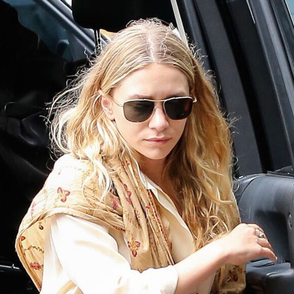 Ashley Olsen, suivie de sa soeur jumelle Mary-Kate qui fume une cigarette, sort d'une voiture à New York, le 8 septembre 2014.
