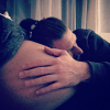 Aurélie Van Daelen au bord de l'accouchement. Son compagnon pose délicatement la tête sur son ventre arrondi. Décembre 2015.
