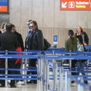 Exclusif - Johnny Hallyday, Anne Marcassus et sa fille Giulia, Laeticia Hallyday - La famille Hallyday arrive à l'aéroport de Roissy pour prendre un vol pour aller passer leurs vacances en Thaïlande avec des amis le 19 décembre 2015