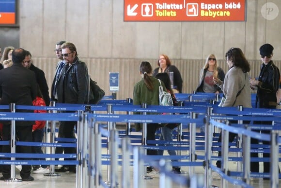 Exclusif - Johnny Hallyday, Anne Marcassus et sa fille Giulia, Laeticia Hallyday - La famille Hallyday arrive à l'aéroport de Roissy pour prendre un vol pour aller passer leurs vacances en Thaïlande avec des amis le 19 décembre 2015