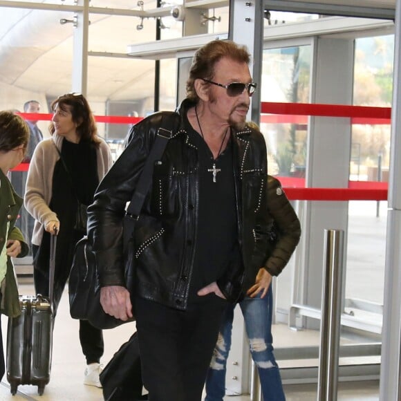 Exclusif - Johnny Hallyday, Anne Marcassus et sa fille Giulia - La famille Hallyday arrive à l'aéroport de Roissy pour prendre un vol pour aller passer leurs vacances en Thaïlande avec des amis le 19 décembre 2015