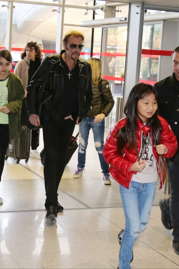 Exclusif - Anne Marcassus et sa fille Giulia, Johnny Hallyday et sa fille Jade - La famille Hallyday arrive à l'aéroport de Roissy pour prendre un vol pour aller passer leurs vacances en Thaïlande avec des amis le 19 décembre 2015