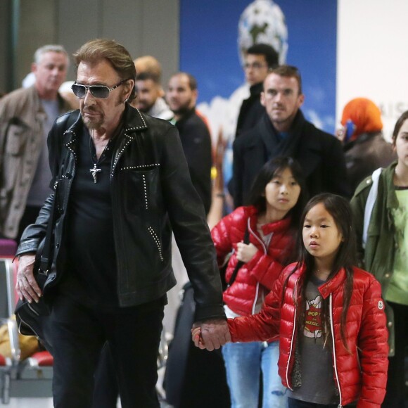 Exclusif - Johnny Hallyday et ses filles Jade et Joy - La famille Hallyday arrive à l'aéroport de Roissy pour prendre un vol pour aller passer leurs vacances en Thaïlande avec des amis le 19 décembre 2015.