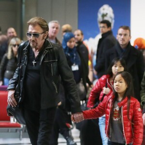 Exclusif - Johnny Hallyday et ses filles Jade et Joy - La famille Hallyday arrive à l'aéroport de Roissy pour prendre un vol pour aller passer leurs vacances en Thaïlande avec des amis le 19 décembre 2015.