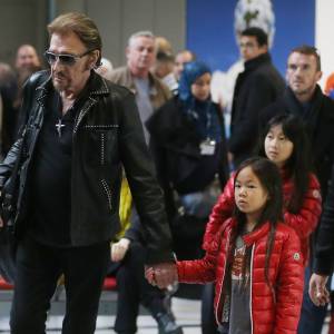 Exclusif - Johnny Hallyday et ses filles Jade et Joy - La famille Hallyday arrive à l'aéroport de Roissy pour prendre un vol pour aller passer leurs vacances en Thaïlande avec des amis le 19 décembre 2015.