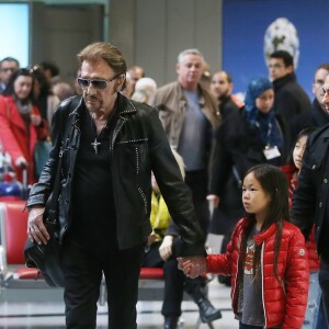 Exclusif - Johnny Hallyday et sa fille Joy - La famille Hallyday arrive à l'aéroport de Roissy pour prendre un vol pour aller passer leurs vacances en Thaïlande avec des amis le 19 décembre 2015.