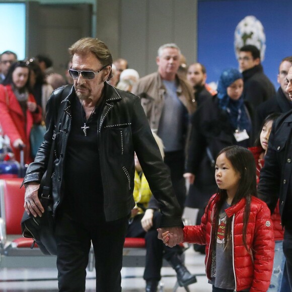Exclusif - Johnny Hallyday et sa fille Joy - La famille Hallyday arrive à l'aéroport de Roissy pour prendre un vol pour aller passer leurs vacances en Thaïlande avec des amis le 19 décembre 2015.