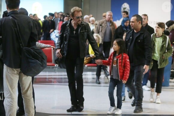 Exclusif - Johnny Hallyday et sa fille Joy - La famille Hallyday arrive à l'aéroport de Roissy pour prendre un vol pour aller passer leurs vacances en Thaïlande avec des amis le 19 décembre 2015.