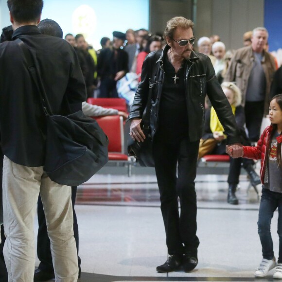 Exclusif - Johnny Hallyday et sa fille Joy - La famille Hallyday arrive à l'aéroport de Roissy pour prendre un vol pour aller passer leurs vacances en Thaïlande avec des amis le 19 décembre 2015.