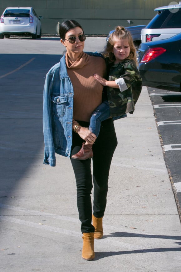 Kourtney Kardashian passe la journée avec ses enfants Mason et Penelope et sa nièce North West à Woodland Hills, habillée d'une veste J Brand, d'un pull à col écharpe Mystylemode, d'un jean noir Lagence et de bottines Saint Laurent. Le 29 décembre 2015.