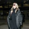 Heidi Klum photographiée à l'aéroport LAX à Los Angeles, porte une tenue entièrement noire, composée d'un manteau en fausse fourrure Stella McCartney et d'un sac matelassé Chanel. Le 5 janvier 2016.