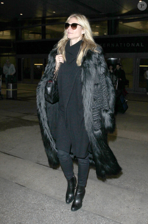 Heidi Klum photographiée à l'aéroport LAX à Los Angeles, porte une tenue entièrement noire, composée d'un manteau en fausse fourrure Stella McCartney et d'un sac matelassé Chanel. Le 5 janvier 2016.
