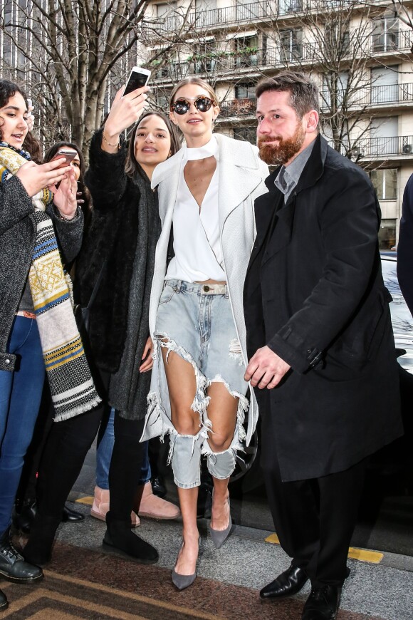 Gigi Hadid rentre à l'hôtel George V après le défilé Chanel, habillée d'un manteau A.L.C., (modèle Richard), d'un top blanc Intermix (collection Exclusive for Intermix), d'un jean OneTeaspoon et de chaussures Stuart Weitzman. Paris, le 26 janvier 2016.