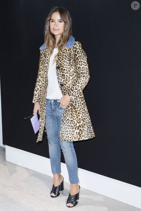 Miroslava Duma assiste au défilé Giorgio Armani Privé (Haute Couture printemps-été 2016) au Palais de Tokyo, habillée d'un manteau léopard à col en fourrure Valentino, d'un top blanc, d'un jean et de sandales Gucci. Paris, le 26 janvier 2016.