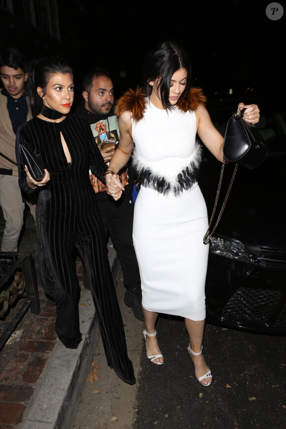 Kourtney Kardashian et Kylie Jenner, vêtue d'une robe blanche et chaussée de sandales Gianvito Rossi (modèle Carlie), quittent la soirée de lancement de la marque OUAI à Los Angeles. Le 4 février 2016.
