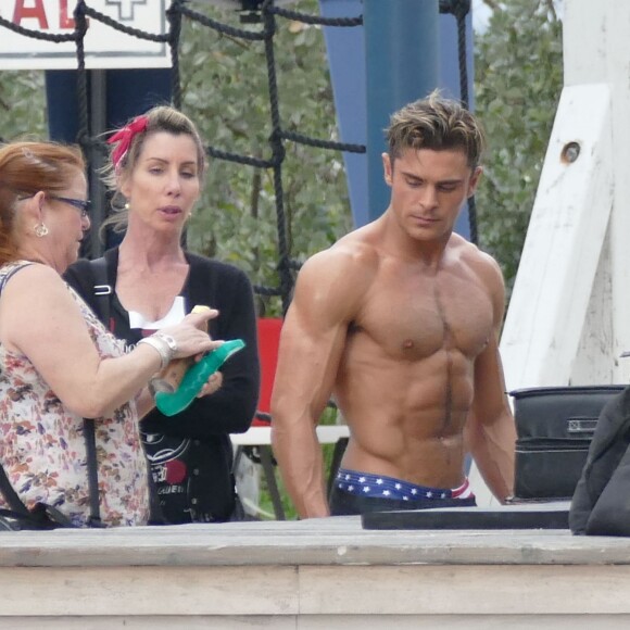 Zac Efron très musclé (il se fait vaporiser de l'huile sur le corps) sur le tournage de Baywatch à Miami Beach, le 5 mars 2016.